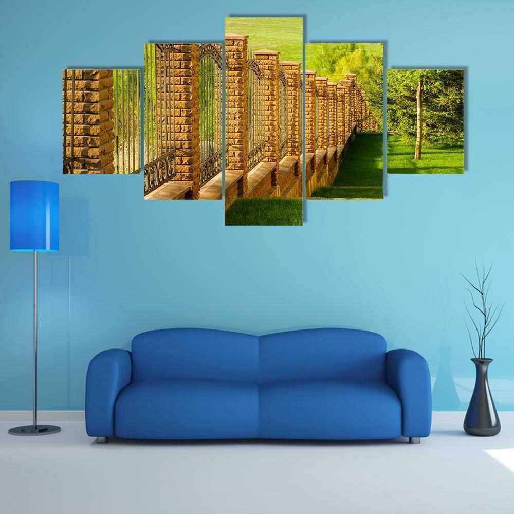 Forged Fence With Stone Pillars On Green Slope Nature Canvas Wall Art